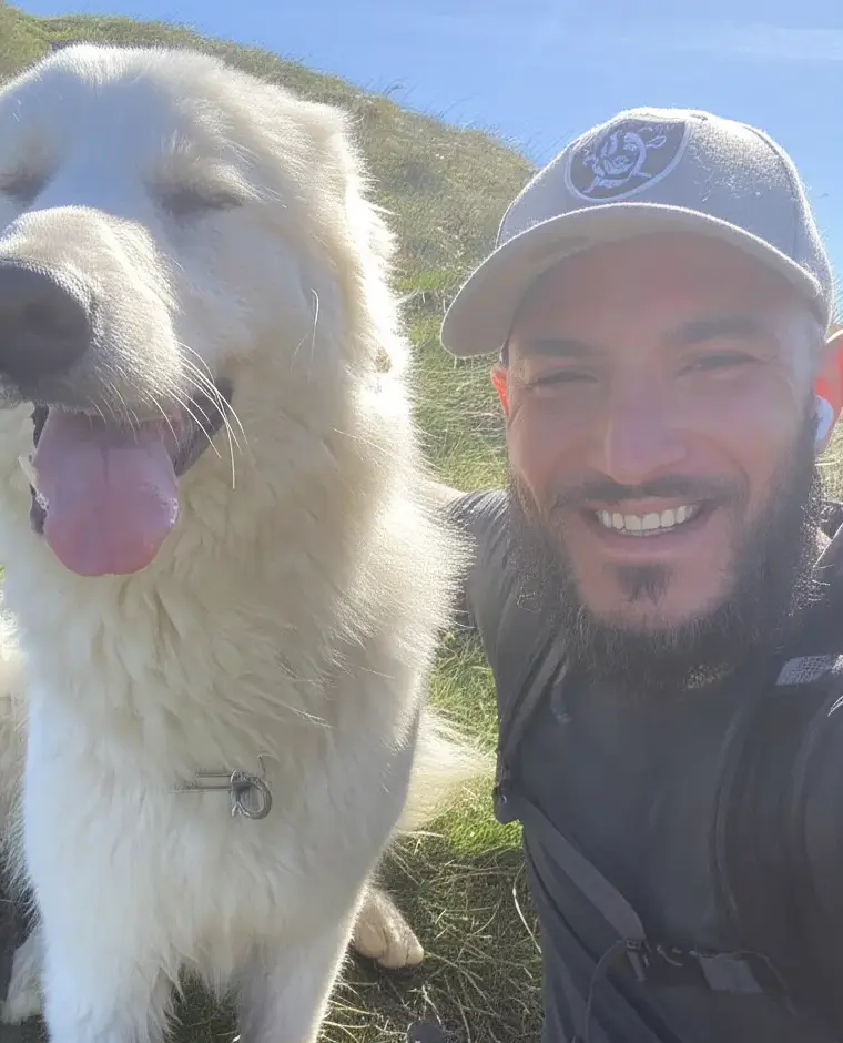 Nicolas Moussa, fondateur de IAether, souriant en randonnée avec son chien blanc.